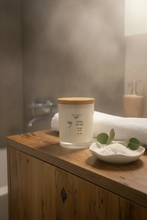 Load image into Gallery viewer, Ocean Sea Salt candle with wooden lid on a wooden surface, wicker basket in the background
